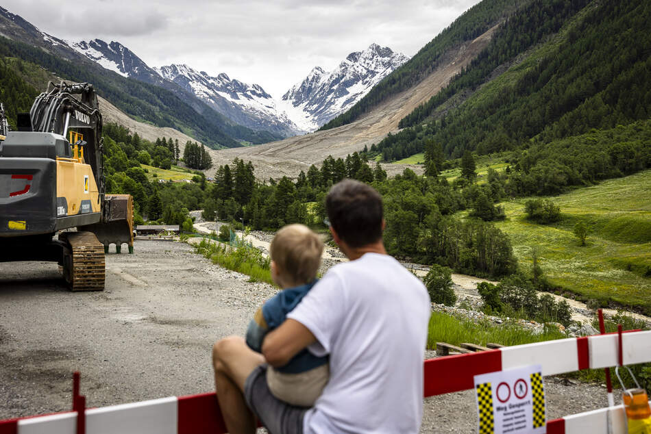 Frana di Blatten nel 2025 Un père et son enfant regardent la zone du glissement de terrain à Blatten - donner de l'espoir en aidant et en soutenant sur place.