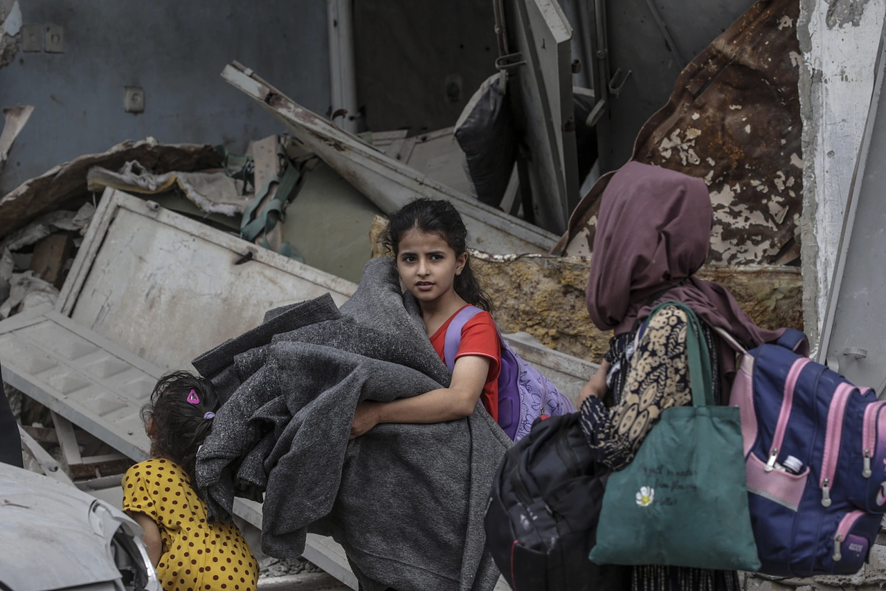 Una bambina di Gaza con le sue cose: costretta a fuggire, ha bisogno di aiuto urgente.