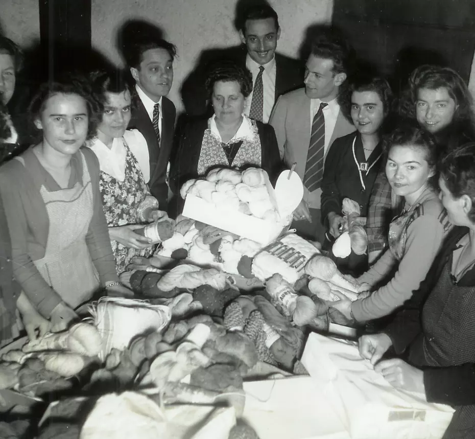 Persone raccolgono gomitoli di lana – campagna del 1951 della Catena della Solidarietà contro il grande freddo.