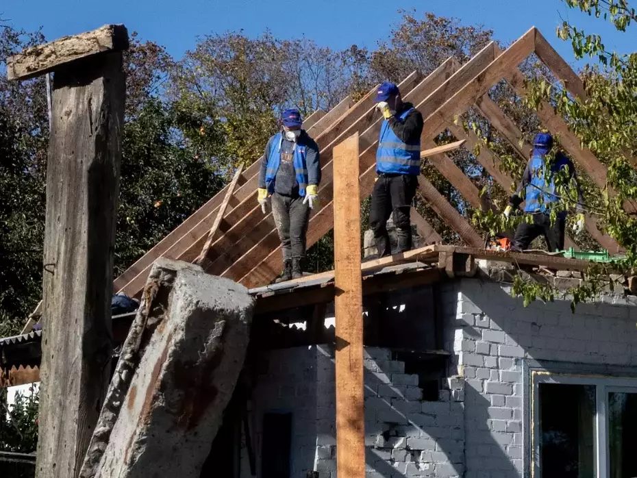 Ricostruire per proteggere Gli operai riparano il telaio di una casa danneggiata: la ricostruzione consente alle famiglie colpite di rimanere nelle loro case.