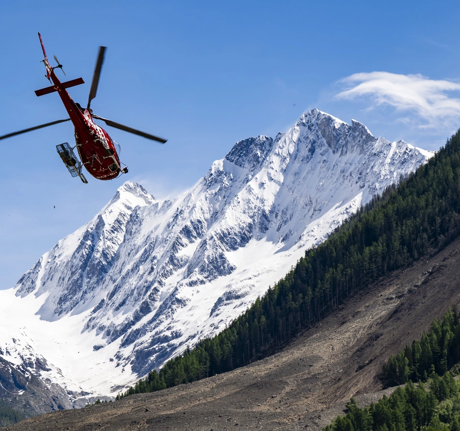 Elicottero di soccorso in azione sull'area della frana di Blatten - donazione urgente per aiuti rapidi.