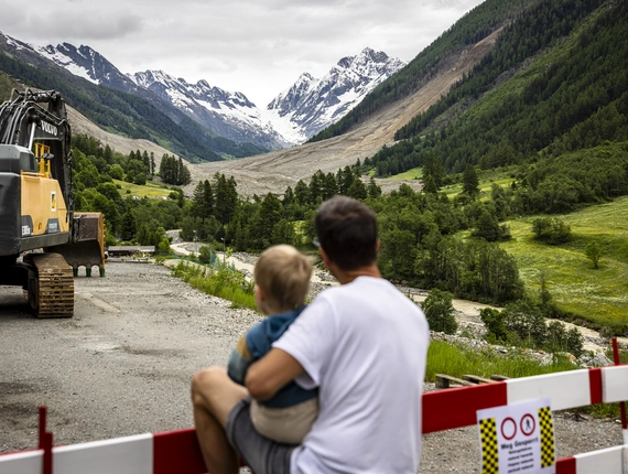 Blatten dopo la frana: uno sguardo verso un futuro incerto Padre e figlio osservano l'area della frana a Blatten: dare speranza attraverso l'aiuto e il sostegno locale.