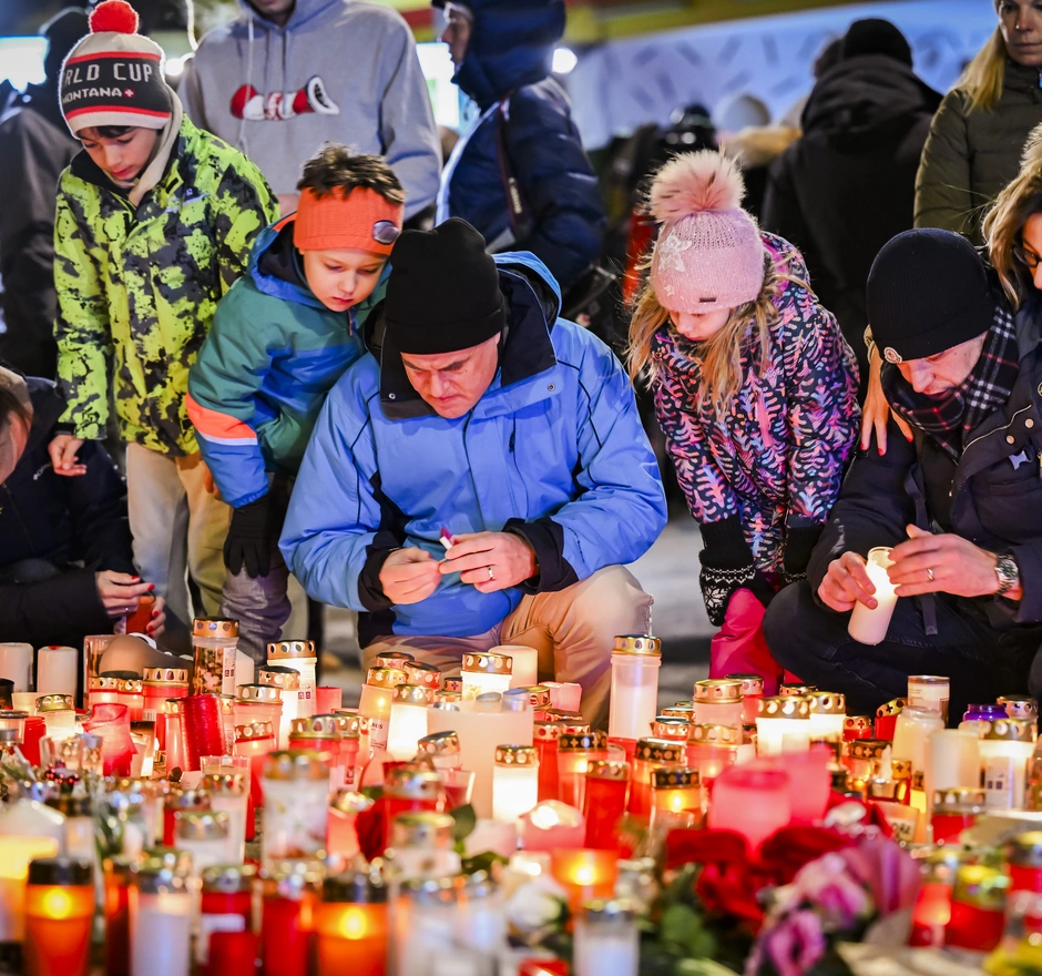 People are paying their respects to the victims with flowers and candles near the area where a unidentified origin fire broke out at the Le Constellation bar and lounge leaving people dead and injured, during New Year’s celebration, in Crans-Montana, Switzerland, Friday, January 2, 2026. According to the latest information available, 40 people died and 119 were injured in a fire at the bar Le Constellation in Crans-Montana on New Year's Eve. (KEYSTONE/Jean-Christophe Bott)