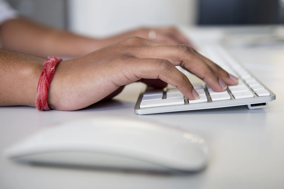 Mani che digitano su un laptop – donazioni online sicure per sostenere la solidarietà con pochi clic.